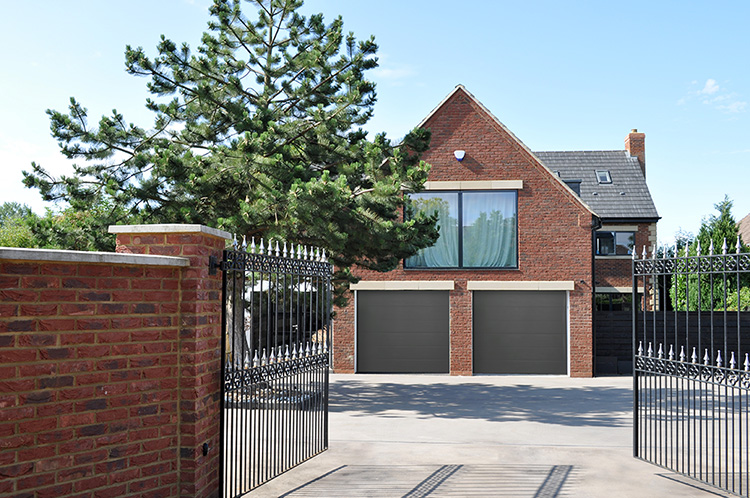 modern home with a gate and a double garage, complete with seceuroglide sectional garage doors